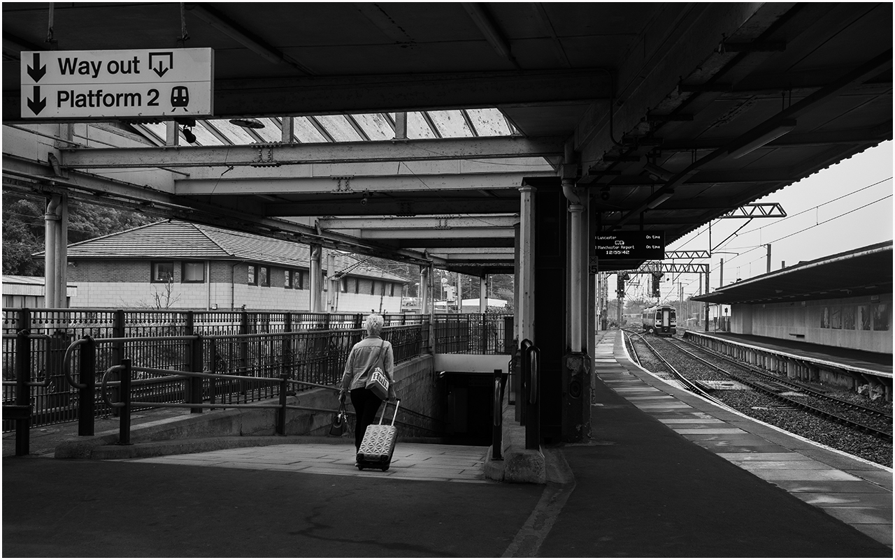 Heading for the train
158816 approaches Carnforth with the 2Y04 12:32 Morecambe - Leeds as a passenger heads over for it.
